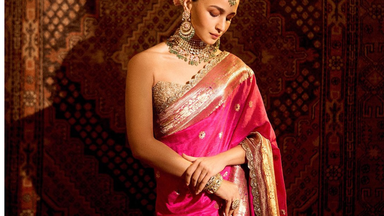 आलियाची घातलेली ही साडी एक बनारसी साडी आहे. साडीचा पदर खूप सुंदर असा गोल्डन एम्ब्रॉयडरी केलेला आहे. या डिझाईनमध्ये मुघल प्रेरित आकृतिबंध जसे की सुंदर अशी गुलाबी रंगाची फुले बनलेली आहेत. 