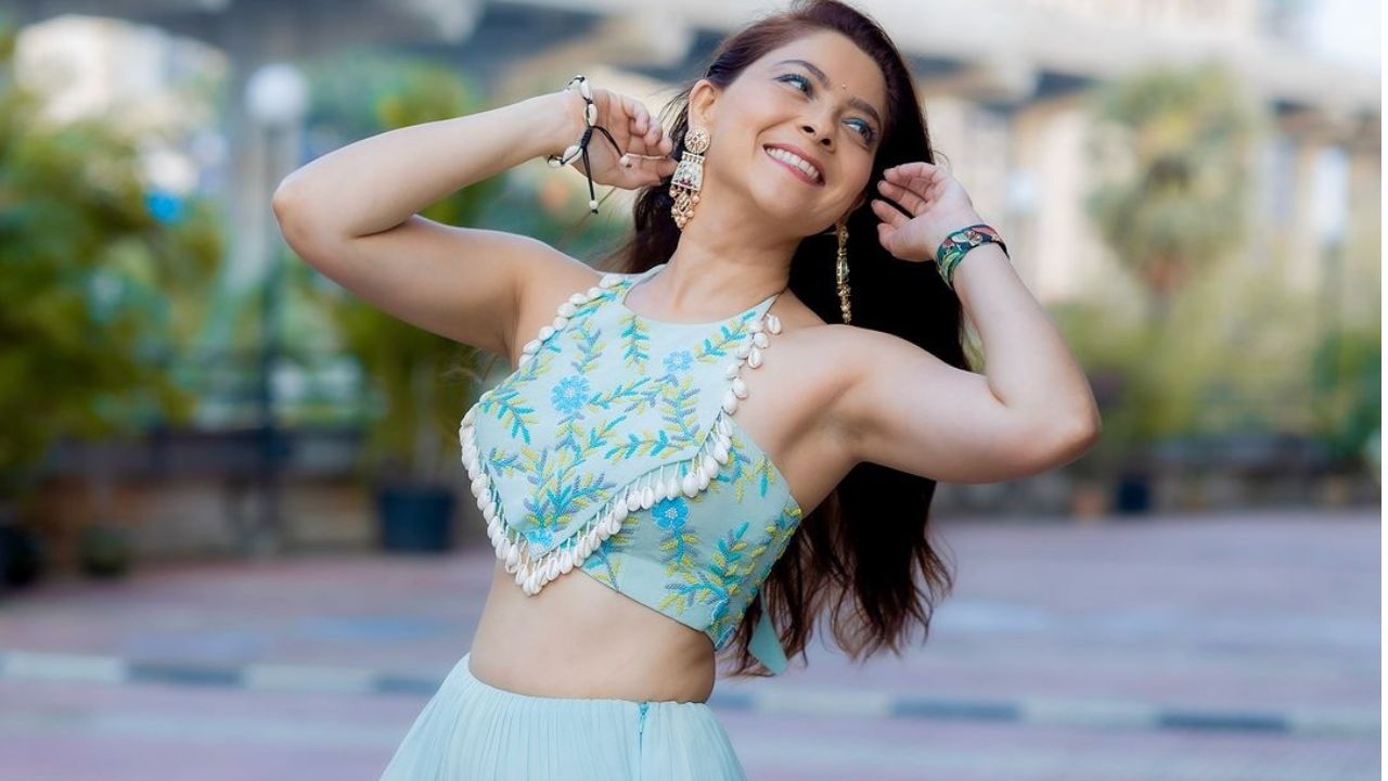 आकाशी रंगाचा घागरा, कानात झुमके आणि ओठांवर आकर्षक असे स्मितहास्य तिच्या सौंदर्याला चार चंद्र लावत आहेत. 