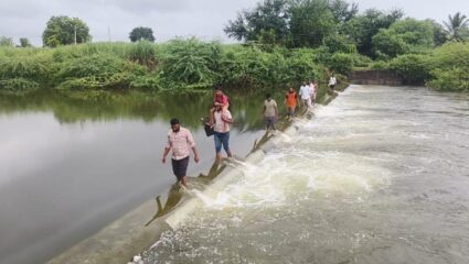 ओढ्यावर पूल नसल्यामुळे नागरिकांचा जीव धोक्यात; बंधाऱ्याच्या भिंतीवरून प्रवास