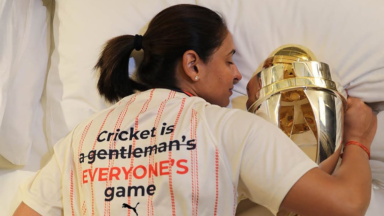 भारताची कर्णधार हरमनप्रीत कौरने सोशल मिडियावर फोटो शेअर केला आहे. यामध्ये ती टीम इंडियाने जिंकलेली ट्राॅफीला मिठी मारुन झोपलेली दिसत आहे, एवढेच नव्हे तर तीने घातलेल्या टी-शर्टवर लिहीले आहे की ‘Cricket is a everyone's game’. फोटो सौजन्य - इंस्टाग्राम 