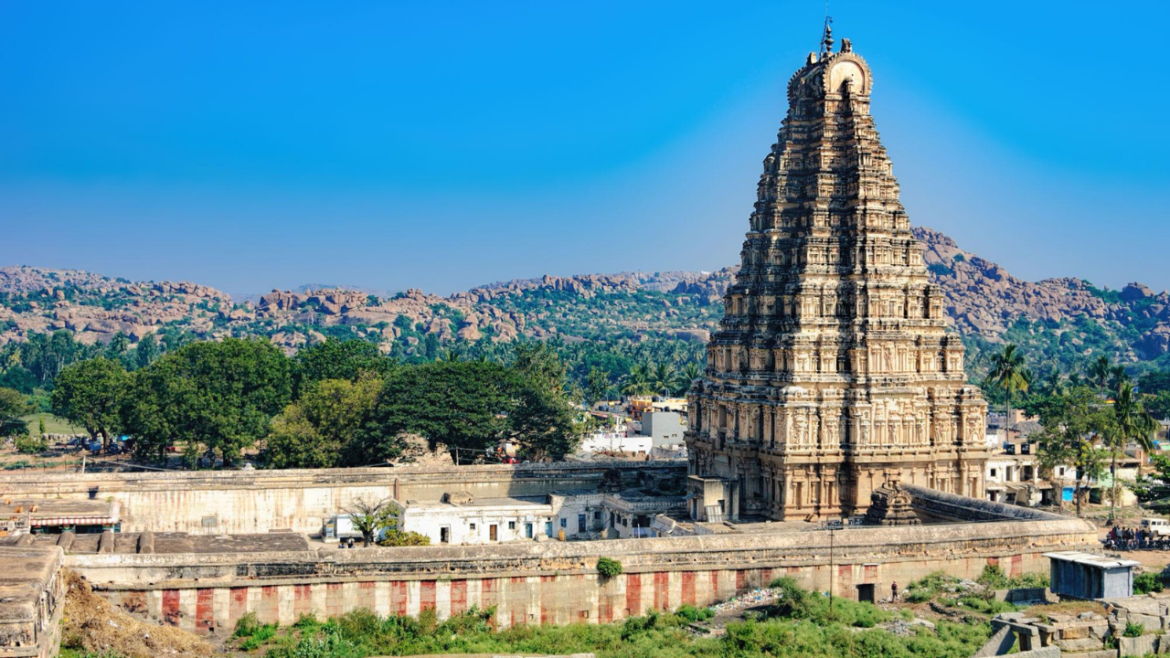 विरुपाक्ष मंदिर – हम्पीची आध्यात्मिक ओळख भगवान शिवाच्या विरुपाक्ष रूपाला समर्पित असलेले हे मंदिर हम्पीतील सर्वात प्राचीन आणि प्रसिद्ध मंदिरांपैकी एक आहे. विजयनगर काळातील भव्य वास्तुकला, उंच गोपुरम आणि सुंदर कोरीवकाम यामुळे हे मंदिर पर्यटकांचे प्रमुख आकर्षण ठरते. आजही येथे नियमित पूजा-अर्चा केली जाते.